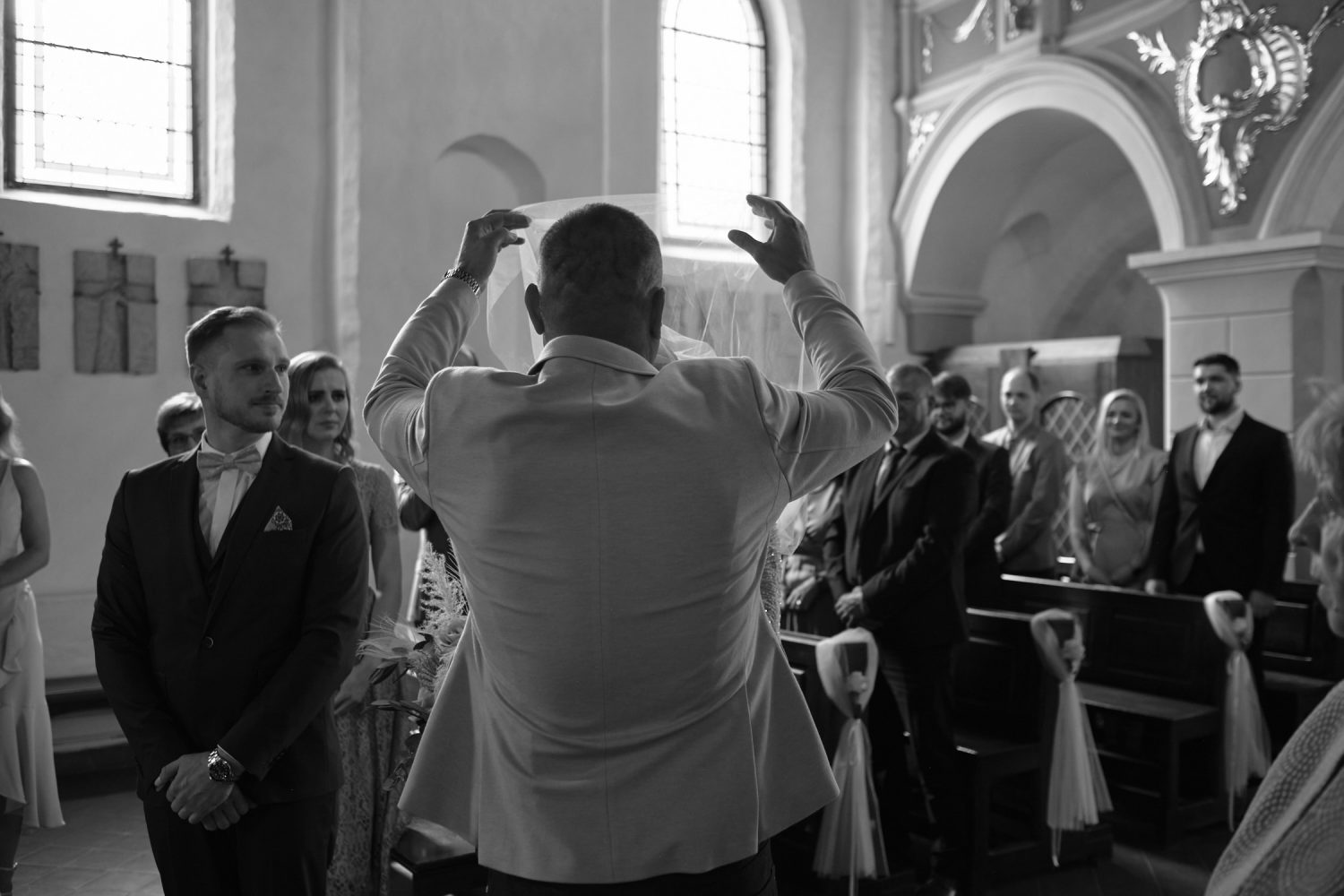 Jaunosios krikšto tėtis nuima Indrei veliumą vestuvių ceremonijos metu Kaune